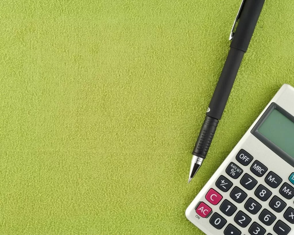 caneta e calculadora representando o conceito de giro de estoque